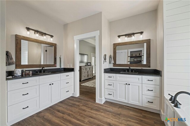 bathroom featuring wood-type flooring, a tub, and vanity