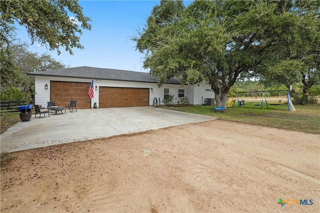 view of front of house featuring a playground, a garage, and a front lawn