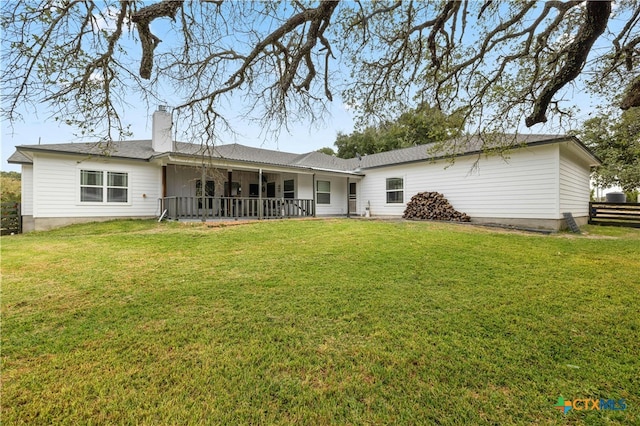 rear view of property featuring a yard