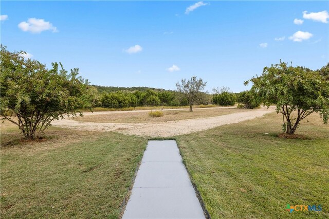 view of home's community with a rural view and a lawn