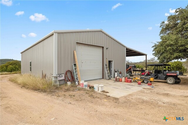 view of outdoor structure with a garage and a carport