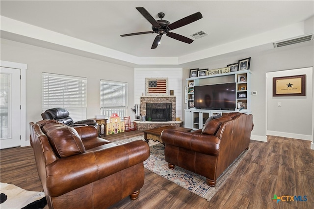 living room featuring a fireplace, dark hardwood / wood-style floors, and ceiling fan