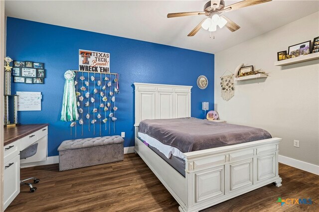 bedroom with dark wood-type flooring, built in desk, and ceiling fan