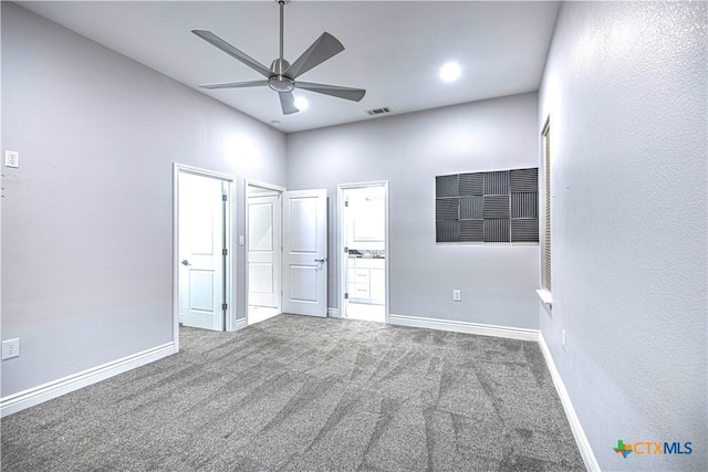 unfurnished bedroom featuring a towering ceiling, carpet floors, and ceiling fan