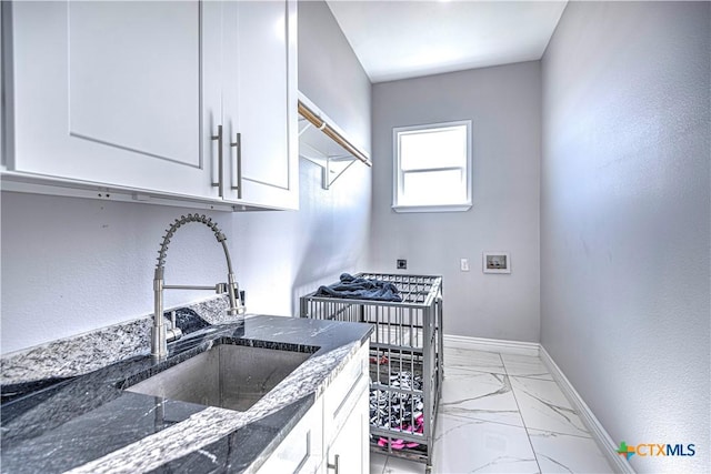 kitchen with white cabinets, sink, and dark stone counters