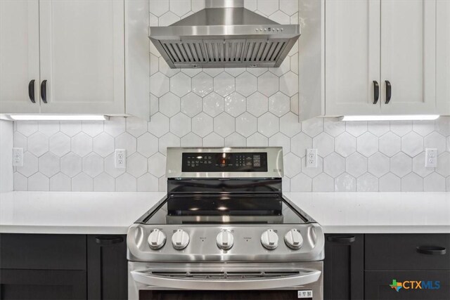 5116 Goliad Dr, Temple, TX 76502 - kitchen featuring wall chimney range hood, stainless steel electric range, tasteful backsplash, light countertops, and white cabinets