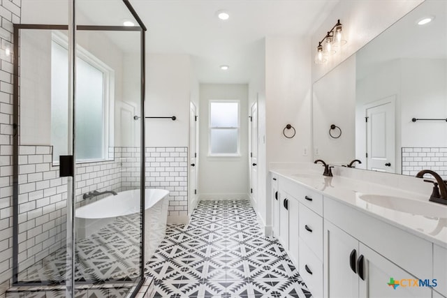 bathroom featuring vanity, a wealth of natural light, tile patterned flooring, and separate shower and tub