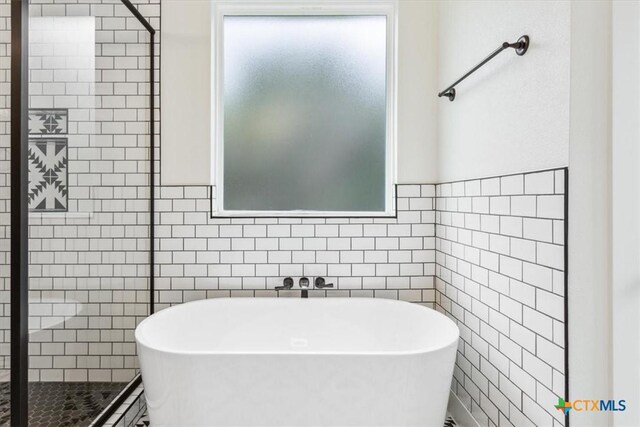 5116 Goliad Dr, Temple, TX 76502 - bathroom featuring tile walls, a freestanding tub, and a shower stall