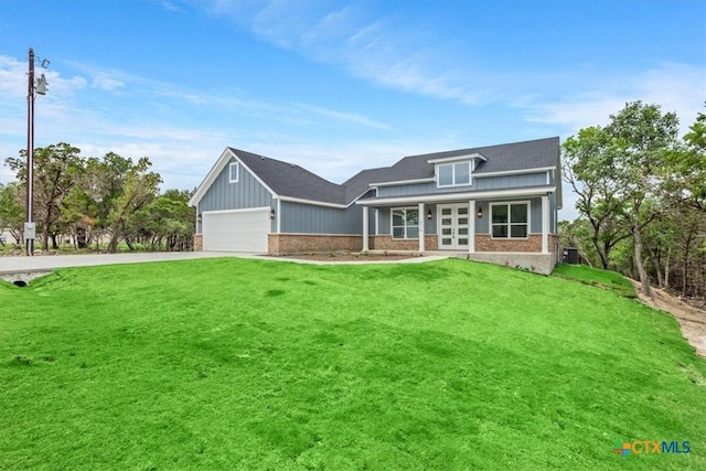 5116 Goliad Dr, Temple, TX 76502 - view of front of home featuring french doors, driveway, a front yard, and brick siding