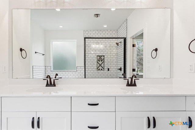 bathroom featuring an enclosed shower, vanity, and decorative backsplash