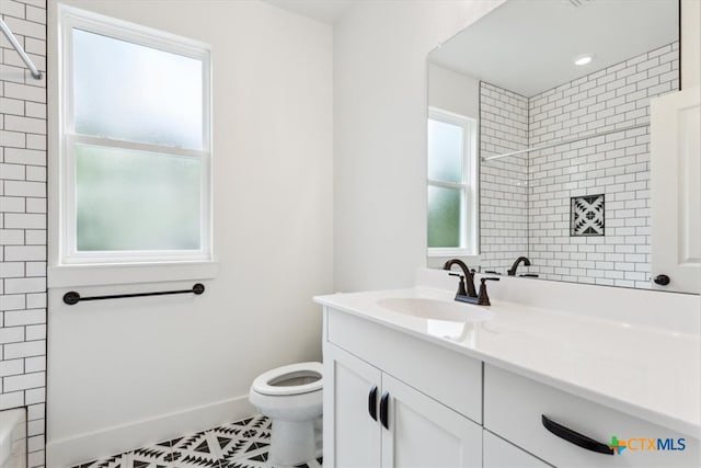 bathroom featuring toilet, vanity, tile patterned floors, and tiled shower