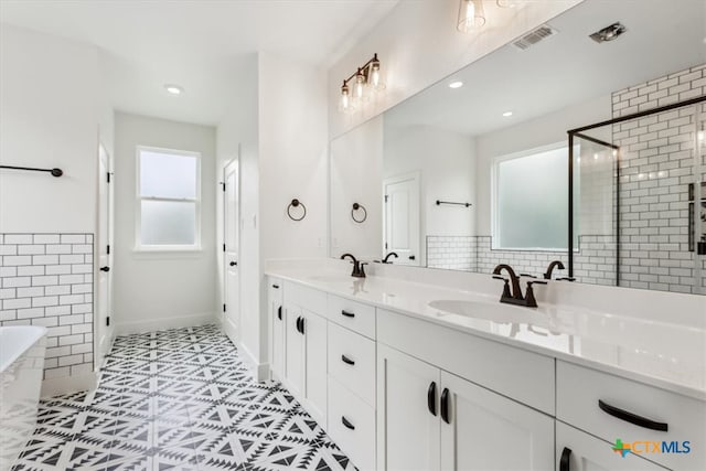 bathroom with shower with separate bathtub, vanity, and tile patterned flooring