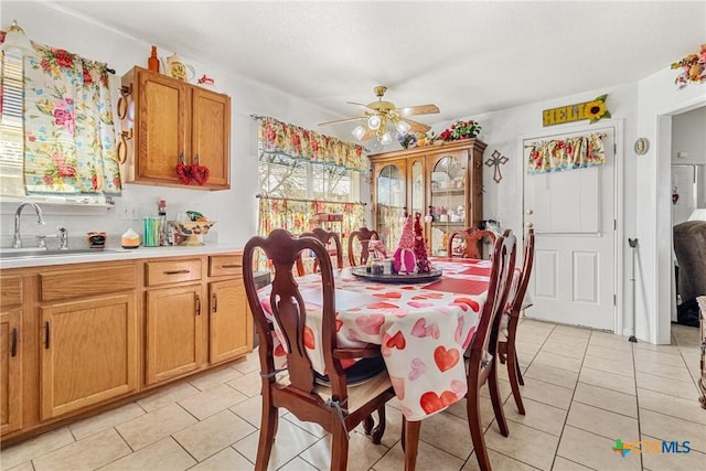 dining area with ceiling fan, sink, and light tile patterned floors