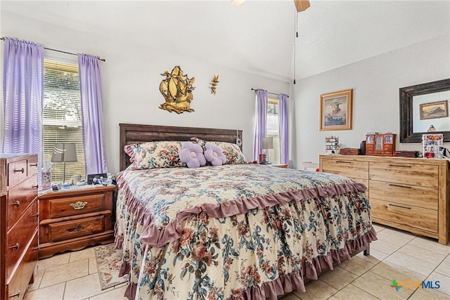 tiled bedroom with ceiling fan, vaulted ceiling, and multiple windows