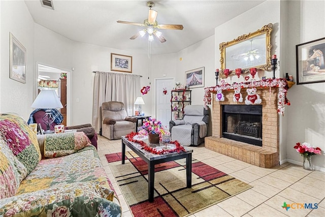 living room featuring light tile patterned floors, a brick fireplace, and ceiling fan