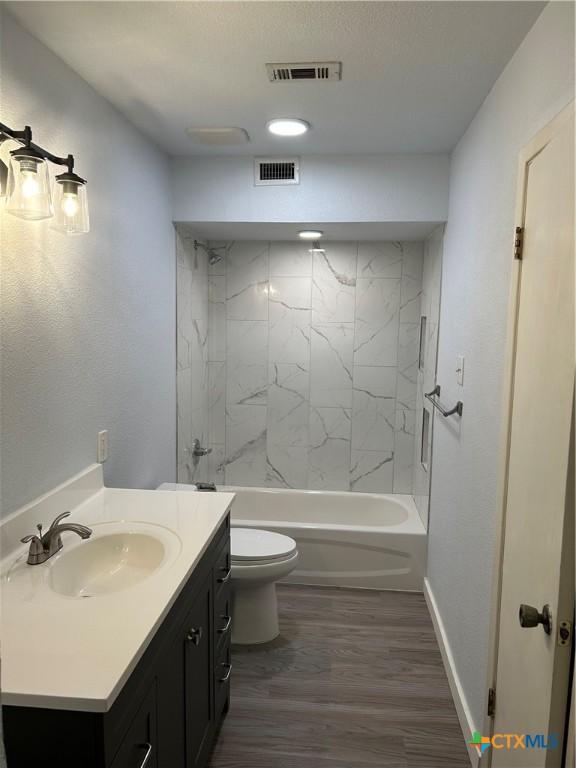 3705 Oakridge Blvd, Harker Heights, TX 76548 - bathroom featuring toilet, wood finished floors, vanity, baseboards, and tub / shower combination