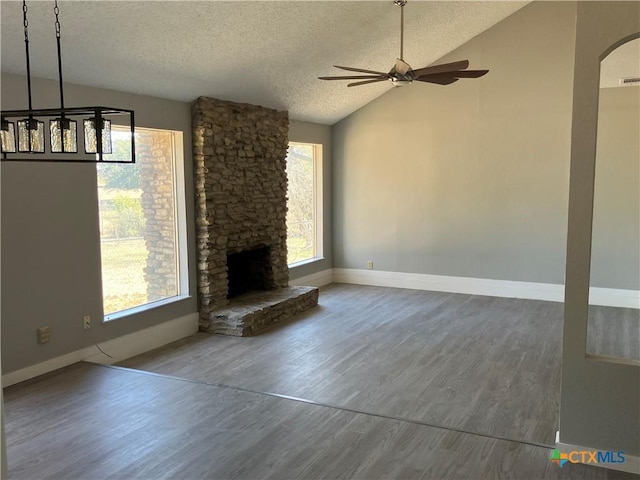 3705 Oakridge Blvd, Harker Heights, TX 76548 - unfurnished living room featuring vaulted ceiling, a textured ceiling, a ceiling fan, plenty of natural light, and baseboards
