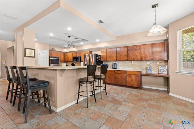 2123 Grizzly Trl, Harker Heights, TX 76548 - kitchen featuring stainless steel appliances, brown cabinets, tasteful backsplash, light stone finish flooring, and light countertops