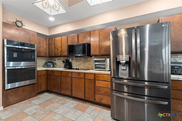 2123 Grizzly Trl, Harker Heights, TX 76548 - kitchen featuring stainless steel appliances, light countertops, tasteful backsplash, and brown cabinetry