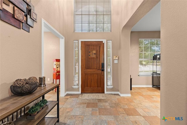 2123 Grizzly Trl, Harker Heights, TX 76548 - foyer entrance with arched walkways, stone tile floors, a towering ceiling, and a textured wall