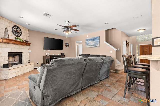 2123 Grizzly Trl, Harker Heights, TX 76548 - living area featuring stone tile floors, a ceiling fan, and a fireplace