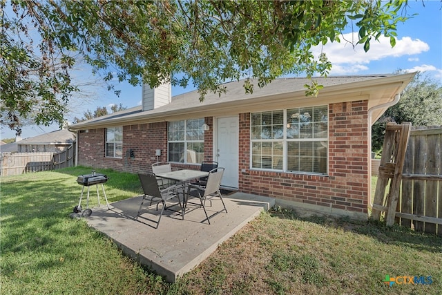 back of property featuring a patio area and a lawn