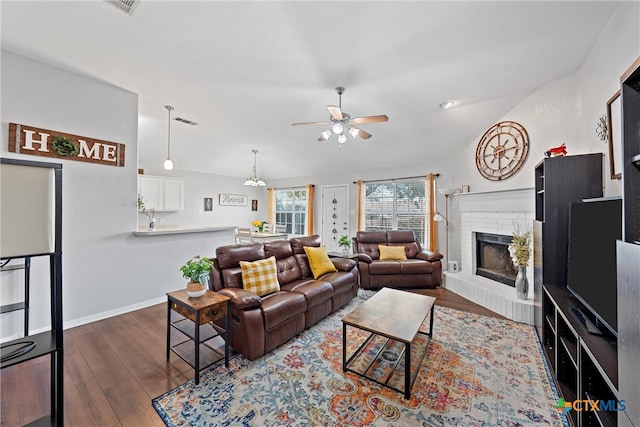 living room with a brick fireplace, lofted ceiling, ceiling fan, and dark hardwood / wood-style flooring