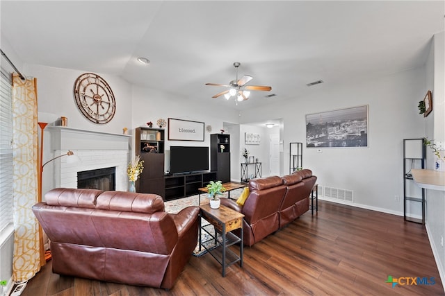 living room with a brick fireplace, lofted ceiling, ceiling fan, and dark hardwood / wood-style flooring