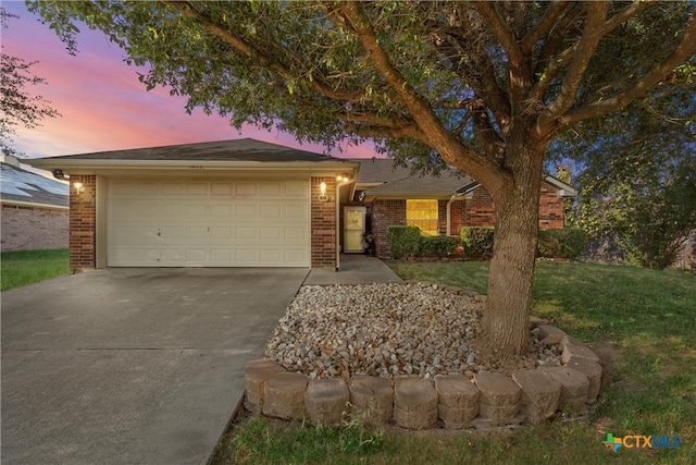 ranch-style home with a garage and a lawn