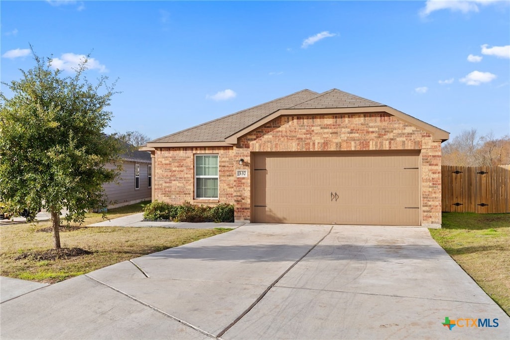 single story home featuring a garage and a front yard