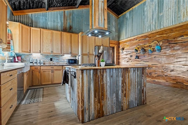 kitchen with light wood-style flooring, a sink, a kitchen island, light countertops, and freestanding refrigerator