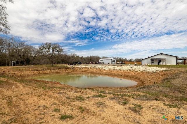 view of yard with a water view, an outbuilding, and an outdoor structure