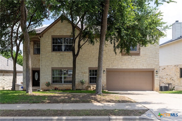 view of front of home featuring central AC unit and a garage