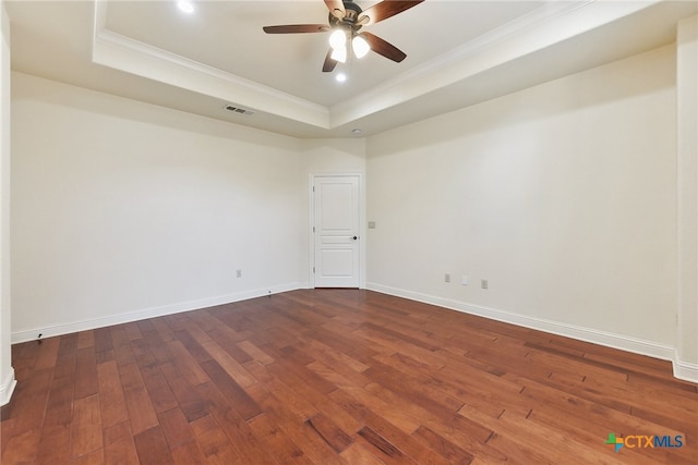 empty room featuring hardwood / wood-style floors, a raised ceiling, ceiling fan, and ornamental molding