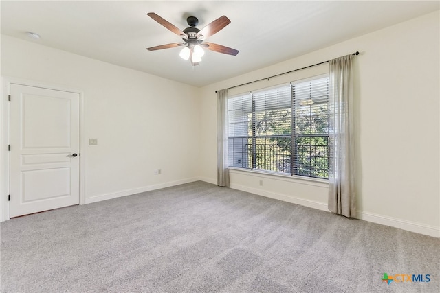 carpeted spare room with ceiling fan