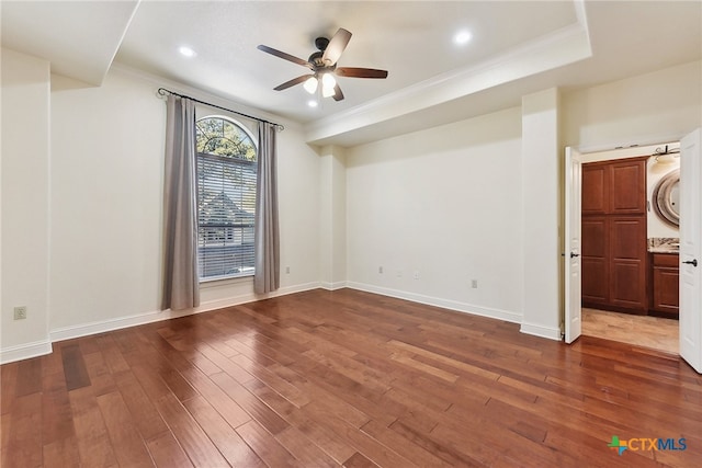 unfurnished room featuring ceiling fan, crown molding, stacked washer / drying machine, and hardwood / wood-style flooring