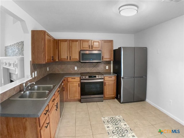 6502 Griffith Loop, Killeen, TX 76549 - kitchen featuring dark countertops, appliances with stainless steel finishes, a sink, baseboards, and decorative backsplash