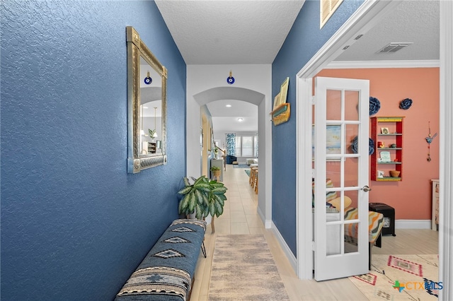 27522 Paraiso Sands, Boerne, TX 78015 - corridor with arched walkways, a textured ceiling, and a textured wall