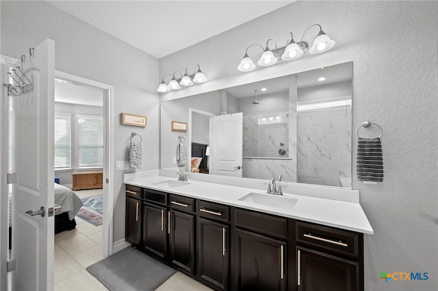 27522 Paraiso Sands, Boerne, TX 78015 - ensuite bathroom featuring double vanity, a marble finish shower, a textured wall, and tile patterned flooring