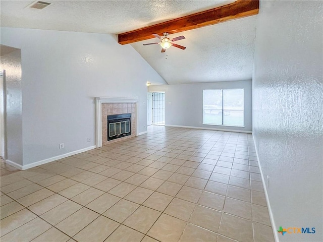 unfurnished living room featuring light tile patterned floors, a tiled fireplace, ceiling fan, a textured ceiling, and baseboards