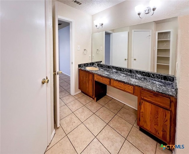 bathroom featuring a textured ceiling, vanity, and tile patterned floors