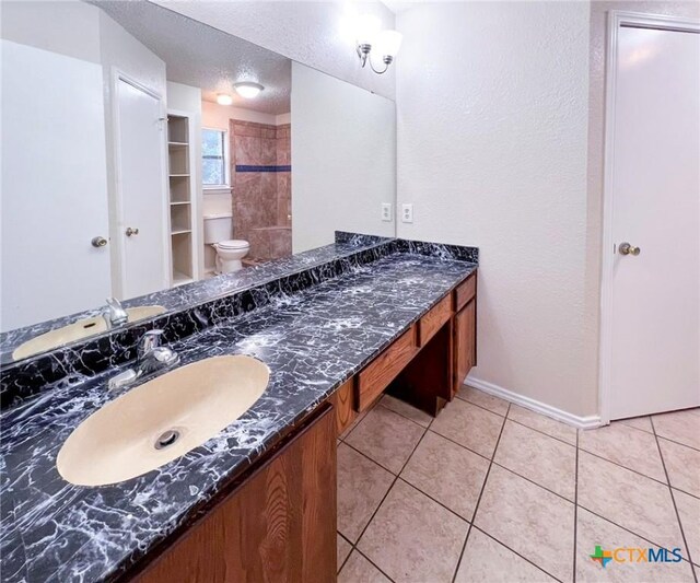 full bathroom with tile patterned floors, vanity, baseboards, a textured ceiling, and toilet