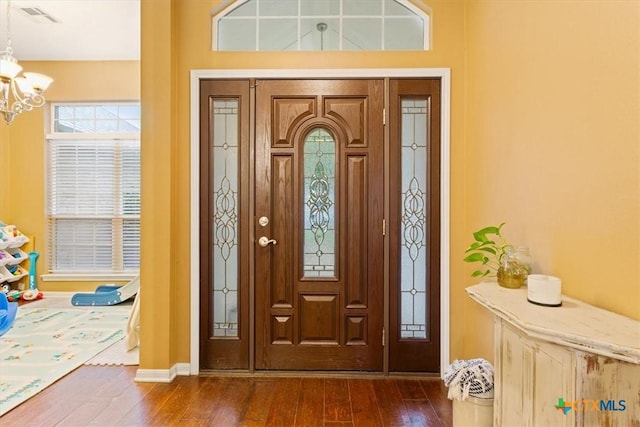 foyer featuring dark hardwood / wood-style flooring and an inviting chandelier