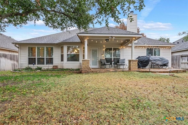 back of house with ceiling fan, a patio area, and a yard