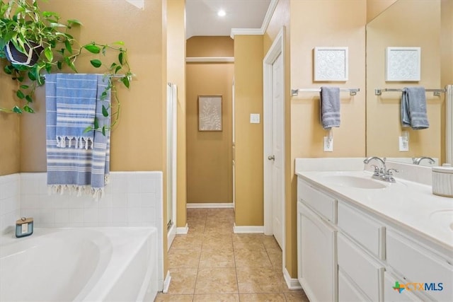 bathroom featuring tile patterned flooring, vanity, a tub to relax in, and ornamental molding