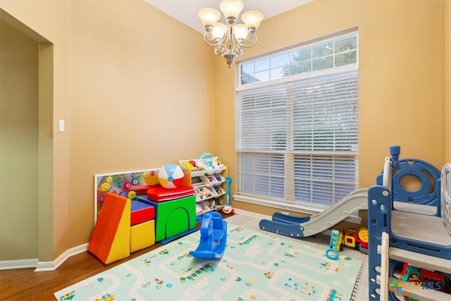 rec room with a chandelier and hardwood / wood-style flooring