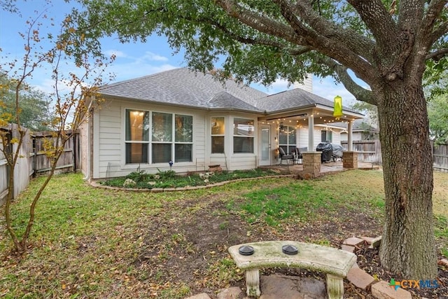 back of house featuring a patio and a lawn