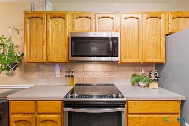 kitchen with stainless steel appliances and tasteful backsplash