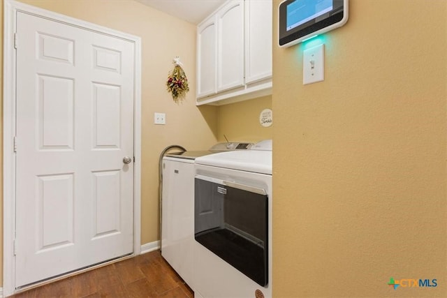 washroom with washer and dryer, cabinets, and dark wood-type flooring