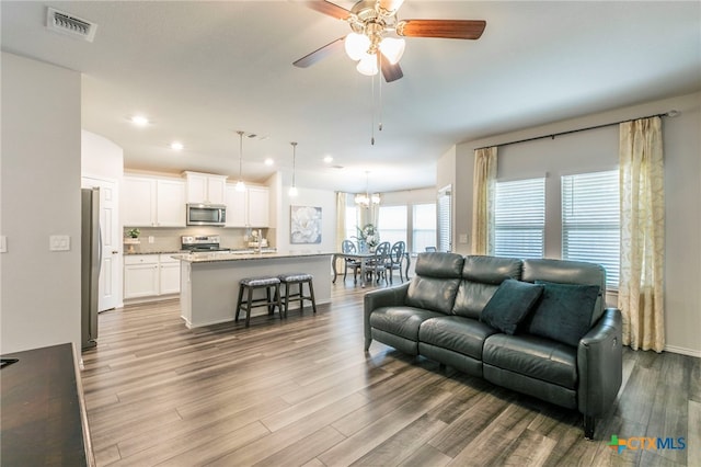 3130 Wigeon Way, Copperas Cove, TX 76522 - living area featuring wood finished floors, ceiling fan, recessed lighting, and a chandelier